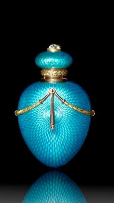 a blue glass bottle with gold trimmings and a handle on it's top