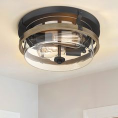 a ceiling light that is hanging from the ceiling in a room with white walls and wood trimmings