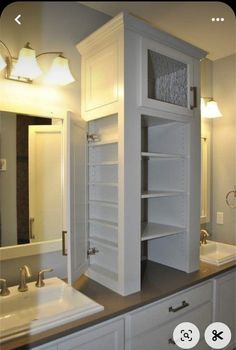 a bathroom with two sinks and an open cabinet in the middle is shown on the phone