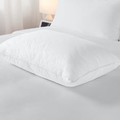 a bed with white sheets and pillows on it