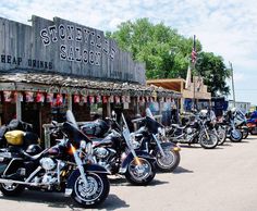 many motorcycles are parked in front of a saloon