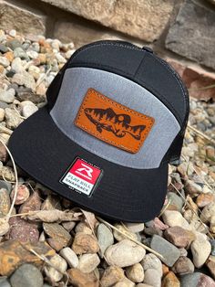 These leather patch Richardson 168 hats are a great way to flaunt your style and look sleek at the same time. Patches made from 100% leather and engraved with a crisp design, Your friends are going to be jealous!  Hat colors available -Heather Gray/Black Mesh -Black -Black/Green Camo -Charcoal/Black Mesh & MANY MORE If a hat color is not listed please message us and we can order in a custom color if needed. Classic trucker cap style built with the Richardson quality and fit you've come to expect. 40+ colorways and 40+ years of sports product experience are just a few reasons this remains a best-seller and favorite cap for teams, fans, and brands alike. Western Style Baseball Cap With Flat Bill For Outdoor, Western Trucker Hat With Leather Patch, Western Style Adjustable Trucker Hat With Leather Patch, Western Style Baseball Cap With Curved Brim For Outdoor, Outdoor Short Brim Hats With Logo Patch, Outdoor Flat Brim Hat With Logo Patch, Black Flat Bill Hat For Hiking, Black Flat Bill Hiking Hat, Black Leather Hat For Outdoor