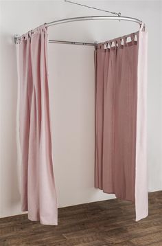 two pink curtains hanging from a metal rod