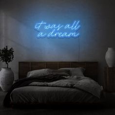 there is a neon sign above the bed that says, it was all a dream