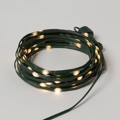 green string lights with white leds are on a white surface and there is also a cord