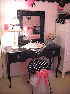 a bedroom with a vanity, mirror and stool next to a dresser in the corner