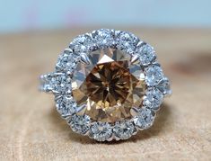 a fancy ring with a brown diamond surrounded by white diamonds