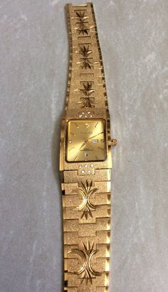 Sunborn men's high quality water resistant watch, having a gold rectangle dial, displaying gold index hoursand having a day and date indicators at the third and sixth hour position, all on a engraved gold designedlinked band. this is a unused still new vintage watch, ready to keep you up with accurate time. this is a water resistant watch and would make anawesome gift item. measurements: bezel/case  1 1/8" x 7/8" rectangle, dial 7/8" x 3/4" rectangle, band width 7/8" and fits a standard 8"wrist perfectly. if a smaller wrist size is needed, we offer free custom sizing. prior to purchasing, please message us for details needed for the free sizing process. we ship fast, the next business day, for a quick delivery to you. may you have a wonderful time shopping, best wishes! Luxury Vintage Watch With Date Indicator, Gold Rectangular Watch Accessories For Formal Occasions, Gold Rectangular Watches With Subdials, Rectangular Metal Dial Watch For Anniversary, Rectangular Watches With Date Display, Rectangular Watches With Date Display For Anniversary, Gold Watches With Rectangular Metal Dial, Rectangular Gold Watch Accessories For Gift, Gold Watches With Date Display And Rectangular Dial