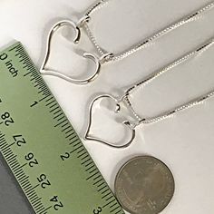 "Ring Necklace Holder, also called an Engagement Ring Holder or Wedding Ring Holder, is a great way to wear your rings when you can't have them on your hands. A Ring Holder Necklace is also a meaningful way to wear the rings of someone dear to you. To see more of my Ring Holder Necklace Designs, here is their section: https://www.etsy.com/shop/AliCArt?ref=l2-shopheader-name&section_id=19372510 To put your rings on the holder, slide the chain off one top loop, put your ring through the openin Ring Halter, Ring Necklace Holder, Wedding Ring Holder Necklace, Ring Keeper Necklace, Wedding Ring Necklace Holder, Ring Holder Pendant, Engagement Ring Holders, Ring Holder Necklace, Ring Holder Wedding