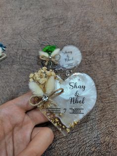 a person holding a heart shaped brooch in their left hand, with the label shavy and nice on it