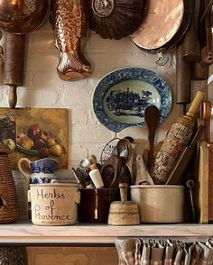 pots, pans and other kitchen utensils sit on a shelf in a kitchen