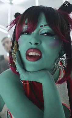 a woman with red hair and green makeup