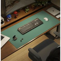 a computer keyboard sitting on top of a desk next to a mouse pad and laptop