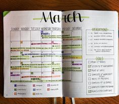 an open planner is sitting on a wooden table with the word march written in it