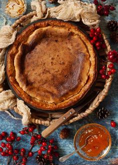 a pie sitting on top of a table next to some cranberries and nuts