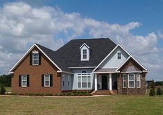 a large brick house in the middle of a field