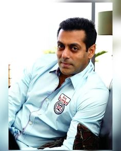 a man sitting in a chair wearing a blue shirt