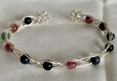 These Celtic inspired knot bracelets, made with tarnish resistant silvertone wire and natural stone beads, are a beautiful look for any wrist. They come in a variety of natural stone materials and your choice of either swirls, pentagram, or triquetra on the ends. *For stone meanings/properties see here Any metals used in jewelry are all nickel free, tarnish resistant (except for copper, which will change color(patina) over time). Metals are either bare copper, silvertone, or goldtone, unless oth Things To Make With Copper Wire, Wire Beaded Bracelets, Wire Bracelets Diy, Wire Bracelet Tutorial, Stone Meanings, Knot Bracelets, Diy Wire Jewelry Rings, Wire Bending, Wire Jewelry Rings