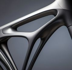 the front end of a bike with black spokes and an intricate design on it