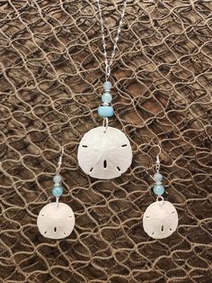 "Gorgeous natural sand dollar necklace with matching earring set. The sand dollars are real and are in their natural condition, and accented with beads in varying shades blue. This would be a gorgeous set for a beach wedding for a bride. bridesmaids, or just a gift for the beach lover in your life. The pendant (approximately 1.5\" across) is set on an 18\", anti-tarnish stainless steel chain that sparkles in the light. Multiple sizes of chain are available. The set is also available in stainless Crafts To Do With Sand Dollars, Handmade Ocean-inspired Round Pendant Jewelry, Adjustable Ocean-inspired Round Pendant Jewelry, Handmade Round Pendant Jewelry For Beach, Nickel Free Ocean-inspired Pendant Jewelry, Nickel-free Ocean-inspired Round Pendant Jewelry, Nickel-free Ocean-inspired Pendant Jewelry, Beach Jewelry With Matching Earrings In Silver, Nickel-free Ocean-inspired Dangle Jewelry