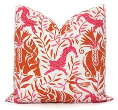 an orange and white pillow with pink animals on it