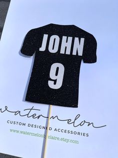 a black and white t - shirt cake topper with the number 9 on it