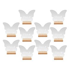 six butterfly shaped acrylic plaques with wooden bases and name tags on each one