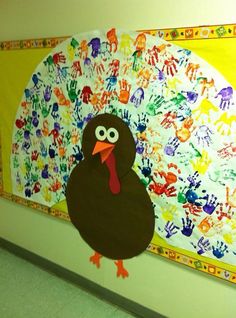 a turkey made out of handprints on a wall next to a colorful painting