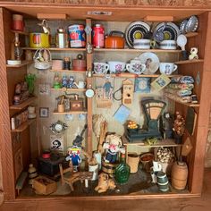 an old fashioned doll house with lots of stuff on it's shelf and shelves