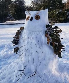 an owl made out of leaves and branches in the snow