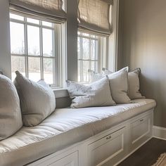 a window seat with several pillows on it