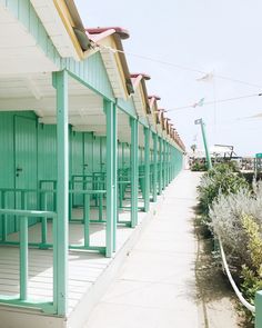 a row of green benches sitting next to each other