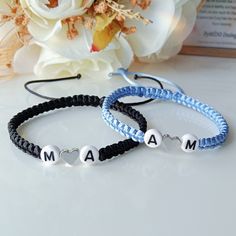 two personalized bracelets on a table with flowers