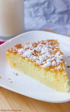 a piece of cake on a white plate next to a glass of milk