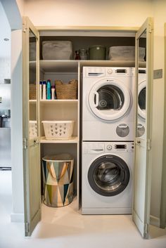 a washer and dryer are in the closet next to each other with baskets