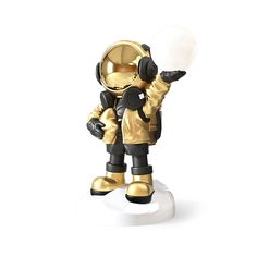 an astronaut figurine holding a white ball in his hand and pointing at it