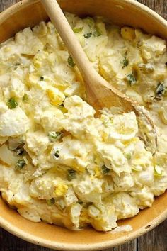 a wooden spoon in a bowl filled with mashed potatoes