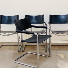 three black leather chairs sitting next to each other in a room with no one on the floor