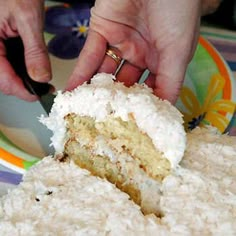 a person cutting into a piece of cake on top of a colorful striped table cloth