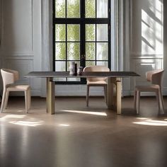 a dining room table and chairs in front of a window