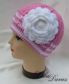 a crocheted hat with a white flower on the top and pink stripes around the brim