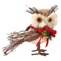 an owl figurine with a red bow and pine cone on it's head