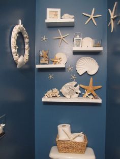 a bathroom decorated in blue and white with starfish, shells, seashells, wreaths and other items