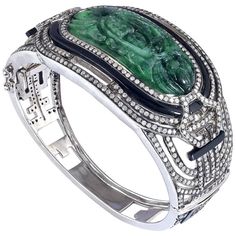 Bold and gorgeous looking this bangle with Jade in center with Diamonds and Black Onyx design is a pretty. This bangle opens on side and in oval in shape. 18Kt: 2.31g Diamond: 5.37Ct Sl: 43.224g JADE: 31.35Ct, ONYX BLACK: 7.71ct Modern Bangle, Diamond Ring Cuts, Flexible Bracelet, Hammered Bangles, Carved Jade, Bangles Making, Diamond Bangles Bracelet, Zircon Jewelry, Gold Bangle Bracelet