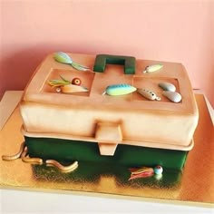 there is a cake that looks like a box with fishing related items on the top