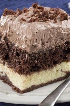 a piece of cake with chocolate frosting on a white plate next to a fork