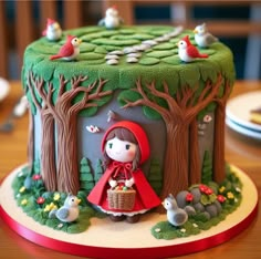 a little red riding on the back of a green cake with trees and birds around it