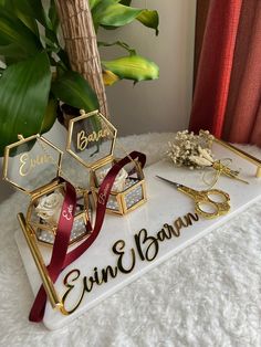 two personalized jewelry displays on a white table with red ribbon and green plant in the background