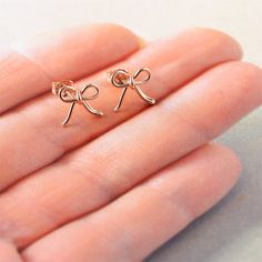 "Bow studs, sterling silver or rose gold bow stud earrings. Bridesmaid gift, modern studs featuring a handcrafted bow made from 20 gauge wire. The earrings have been tumbled and polished. They are secured by clutch-style backs. They measure 10mm (1/2\") across by 8mm tall. These are so sweet and would look great on anyone at any age! Complimentary Gift Wrap! Not quite what you are looking for? Other earrings available: Studs: http://etsy.me/1zWKO9Q Earrings: http://etsy.me/1L0jEjZ Hoops: http:// Rose Gold Jewelry With Bow For Gifts, Rose Gold Bow Jewelry For Wedding, Dainty Rose Gold Earrings As Gift, Rose Gold Earrings For Mother's Day Gift, Earrings Bridesmaid, Etsy Bridesmaid Gifts, Bow Earrings, Everyday Earrings, Rose Earrings