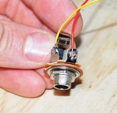 a person is working on an electrical device with wires attached to the end of it